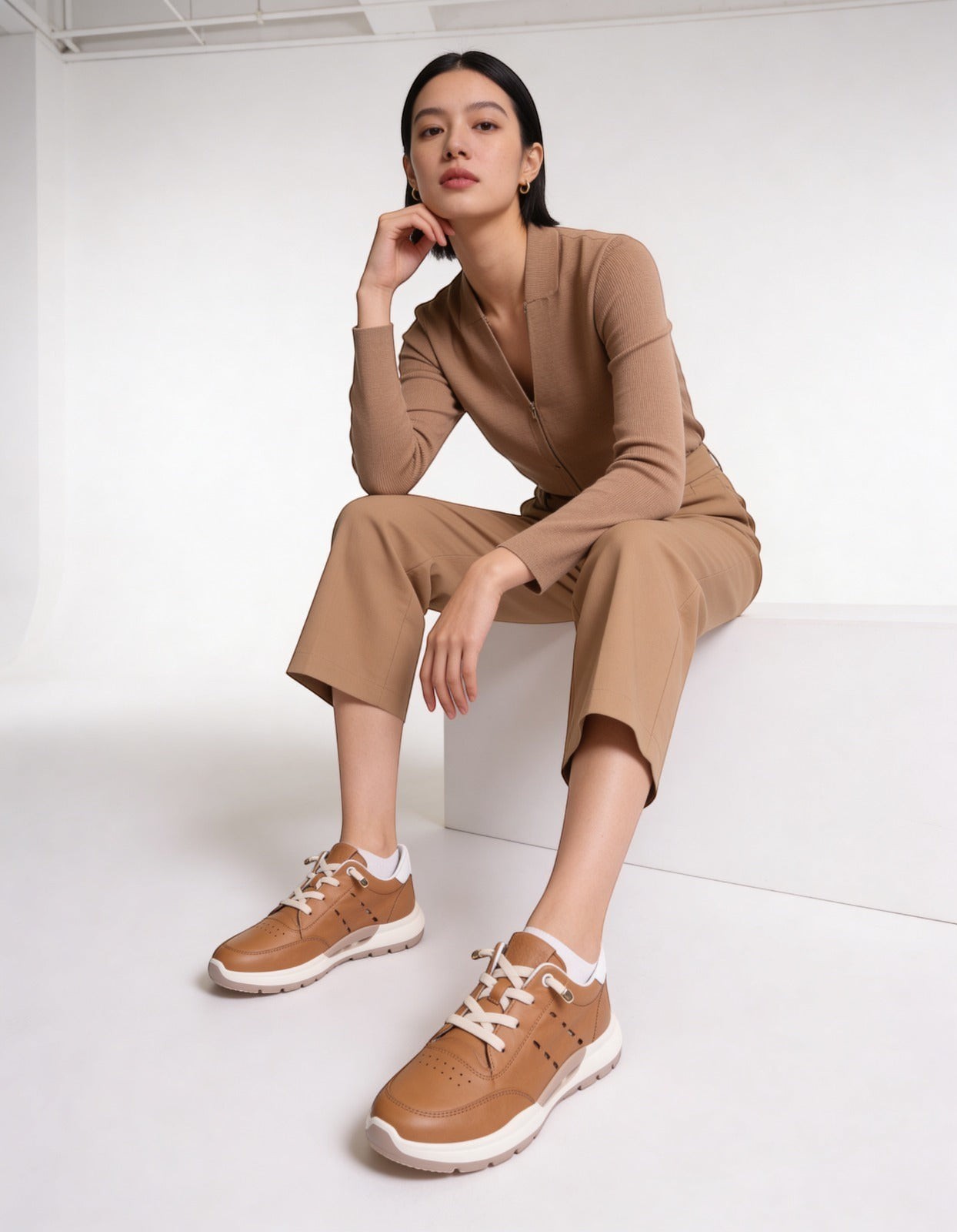 MrCalvano Comfort Walk taba rengi deri sneaker giyen kadın, bej kıyafetlerle kombinlenmiş modern günlük ayakkabı